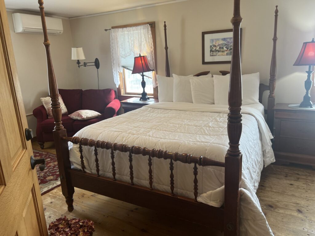 Four poster bed with white comforter and pillows