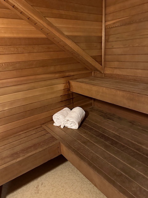 Interior of sauna with two rolled up towels on bench