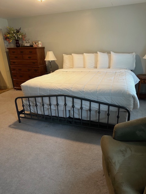 Bed with white comforter and black iron footboard